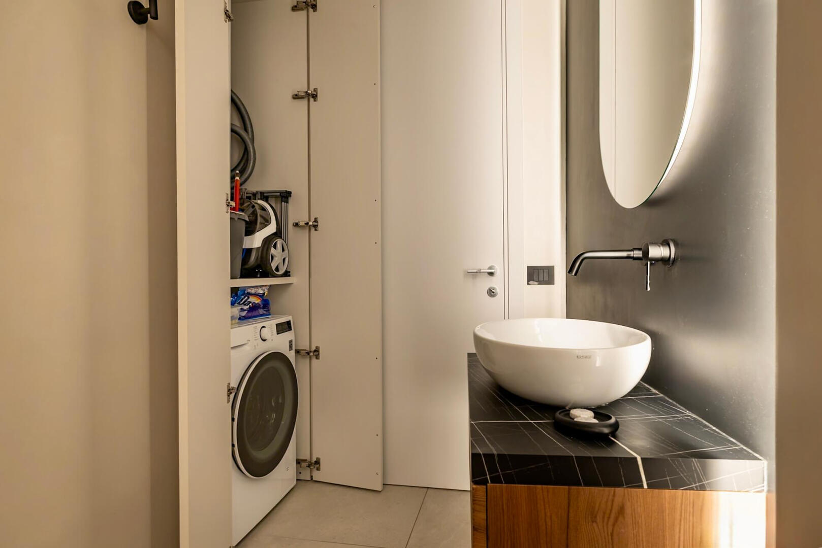 Modern bathroom with walk-in shower, elegant details, and convenient washer for longer stays.